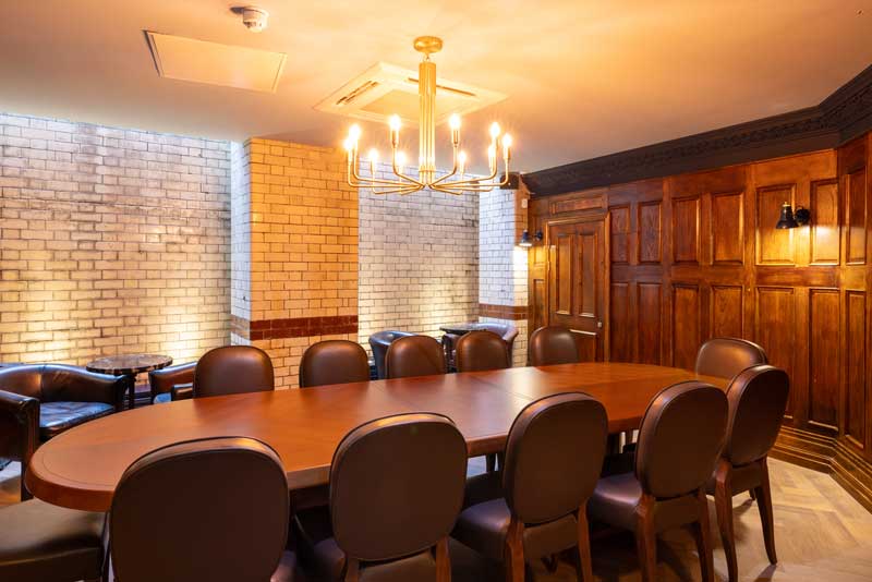 A room with a table and chairs and restored oak panelling